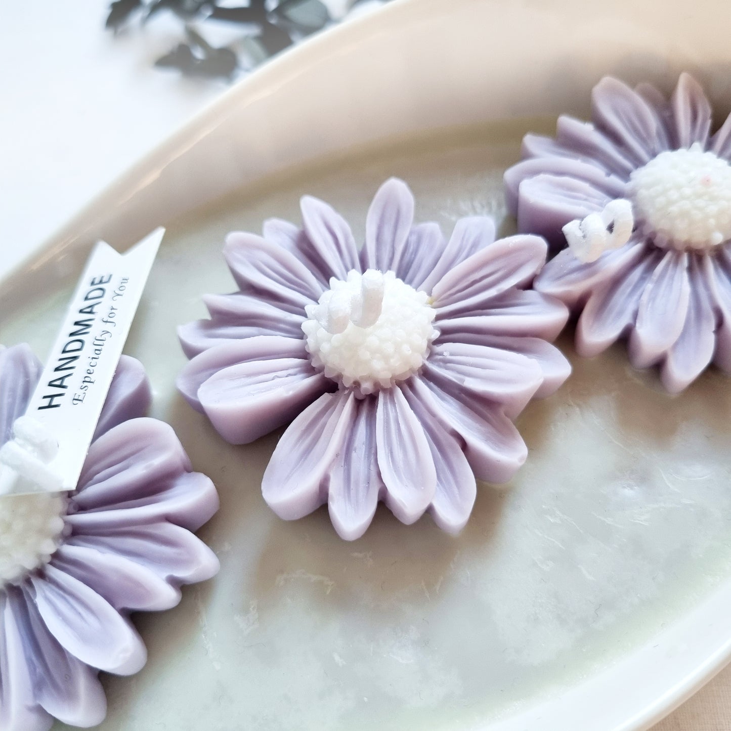 vegane Sojakerze mit Blüten in dekorativer Schiffschale