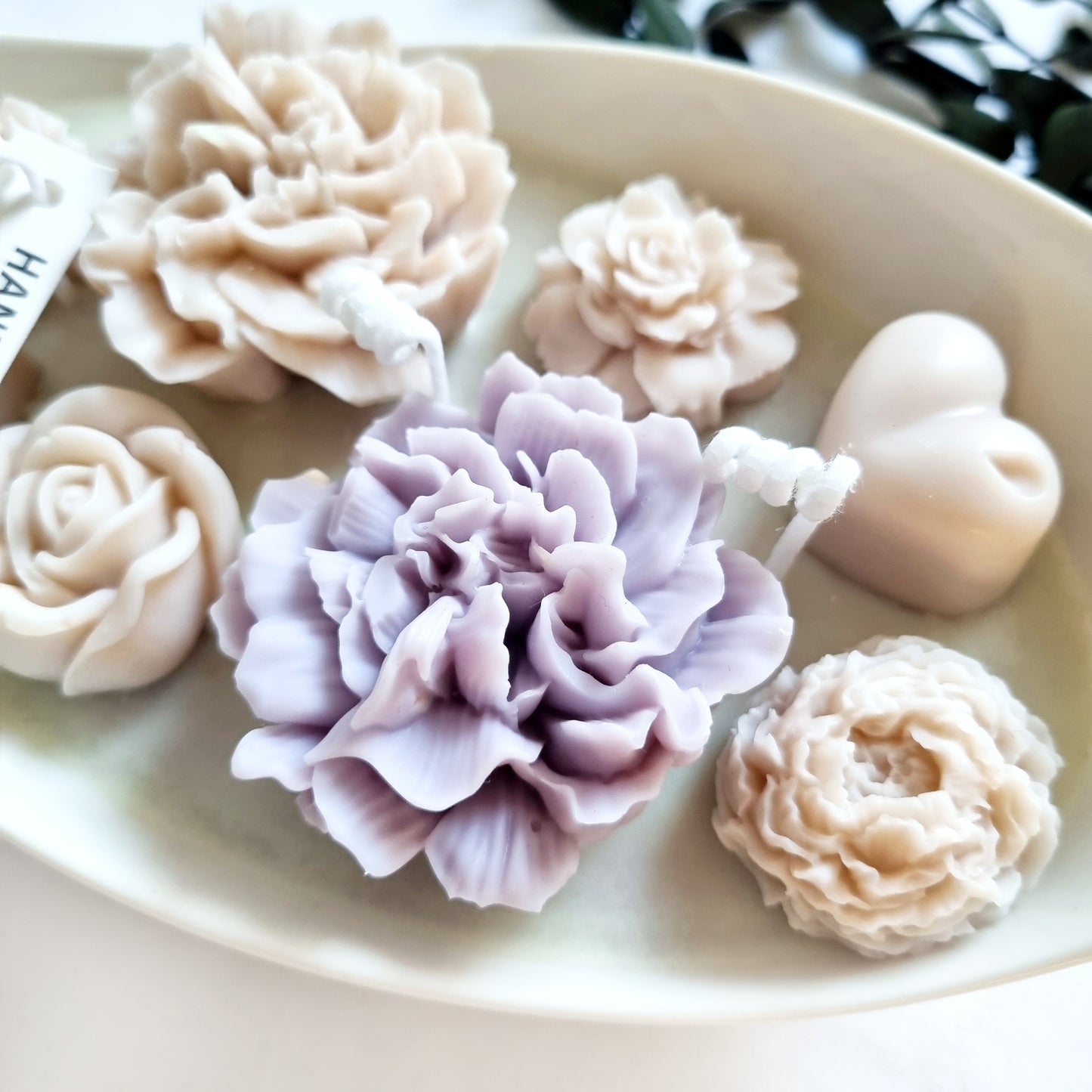 vegane Sojakerze mit Blüten in dekorativer Schiffschale