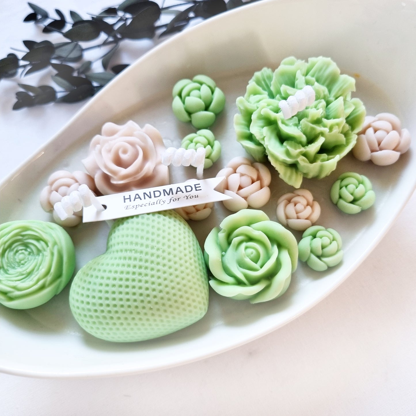 vegane Sojakerze mit Blüten in dekorativer Schiffschale