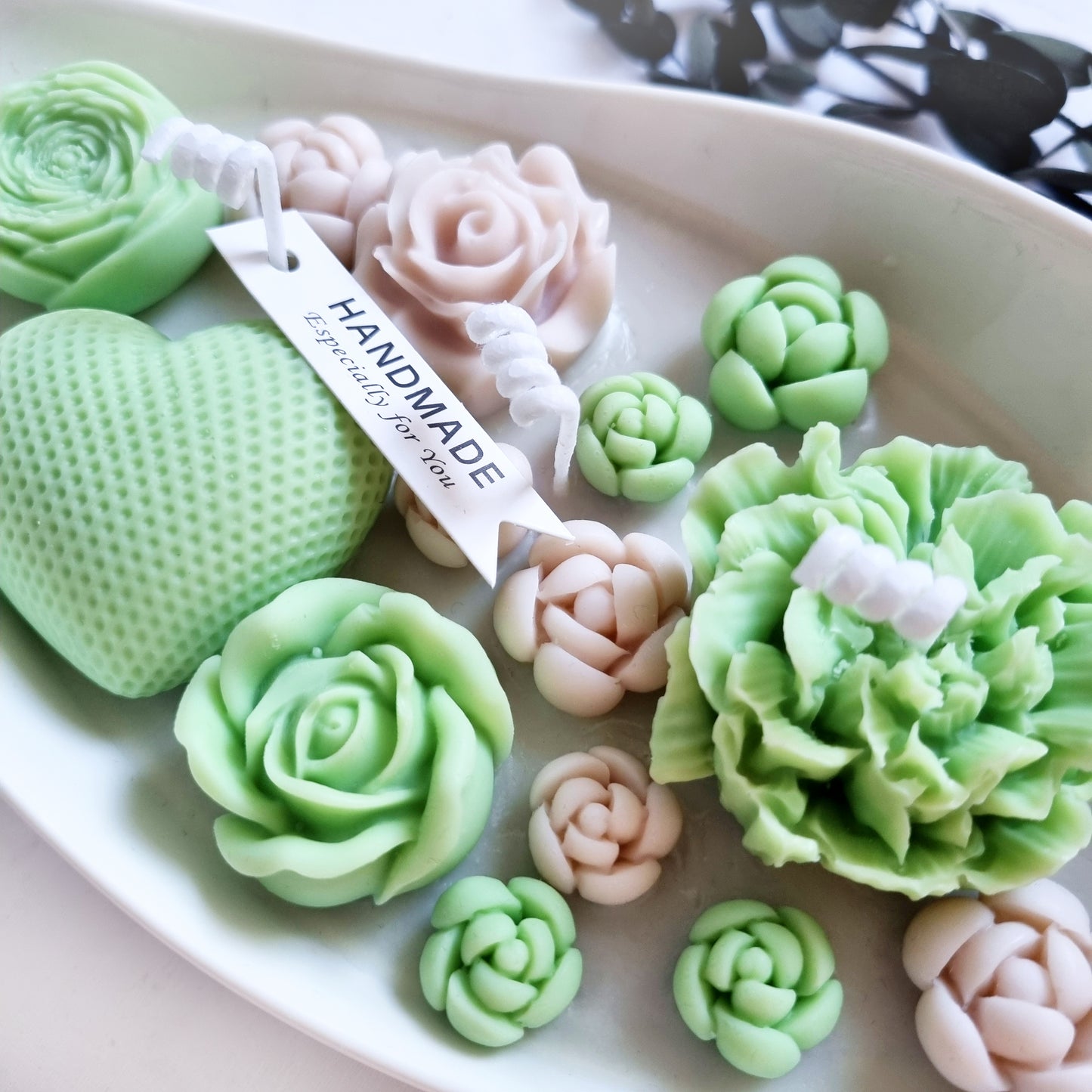 vegane Sojakerze mit Blüten in dekorativer Schiffschale