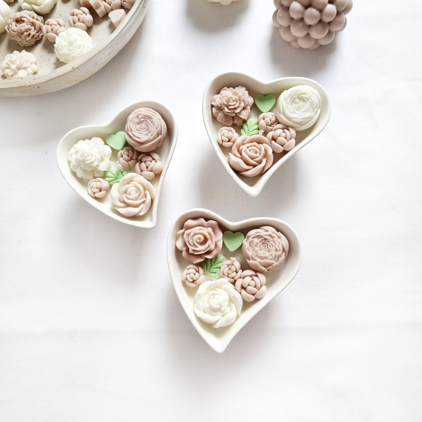 vegane Sojakerze mit Blüten in dekorativer Herzschale