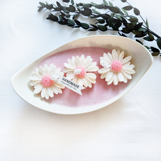 vegane Sojakerze mit Blüten in dekorativer Schiffschale