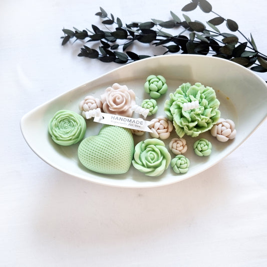 vegane Sojakerze mit Blüten in dekorativer Schiffschale